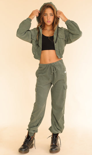 Kaveah Corduroy Cargo Jogger is worn by a young girl, it is in an army green color, practical pockets, and a relaxed silhouette